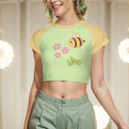 Woman wearing a green and yellow crop top with a bee design, standing indoors.