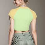 Woman wearing a two-tone crop top and cargo pants against a plain background