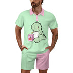 Man wearing a light green polo shirt with a cartoon design and pink shorts on a white background