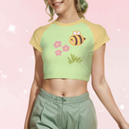 Woman wearing a green and yellow crop top with a bee design on a pink background