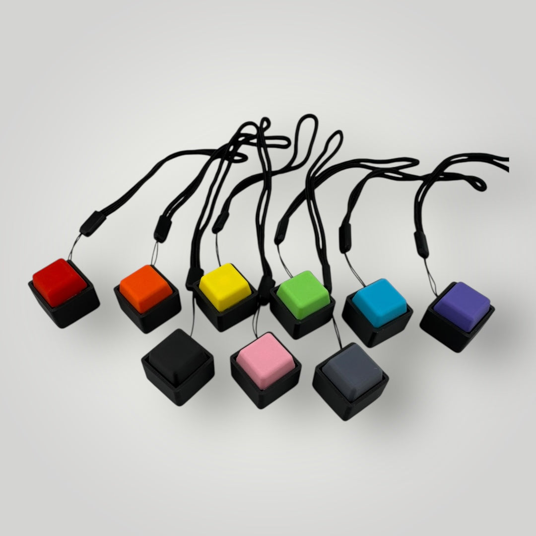 Colorful keychain buttons with black strings on a light gray background