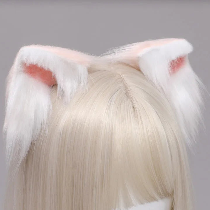 White fluffy cat ears with red accents on a person wearing a blonde wig against a gray background.